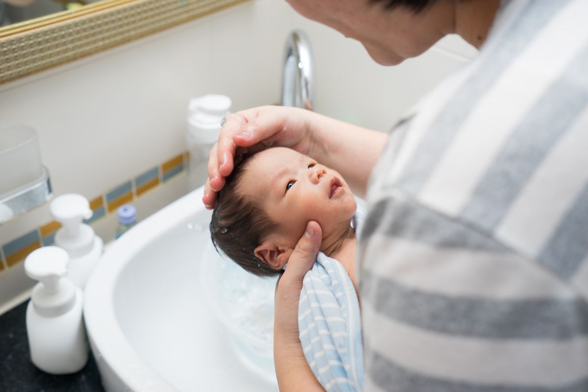 Mother softly bathing her baby